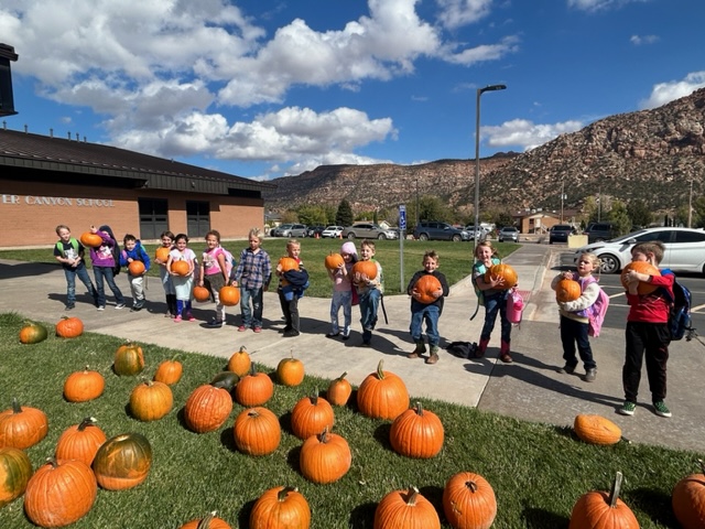 First grade students showing off their pumpkins which were donated to the school by John and Irene Bird.