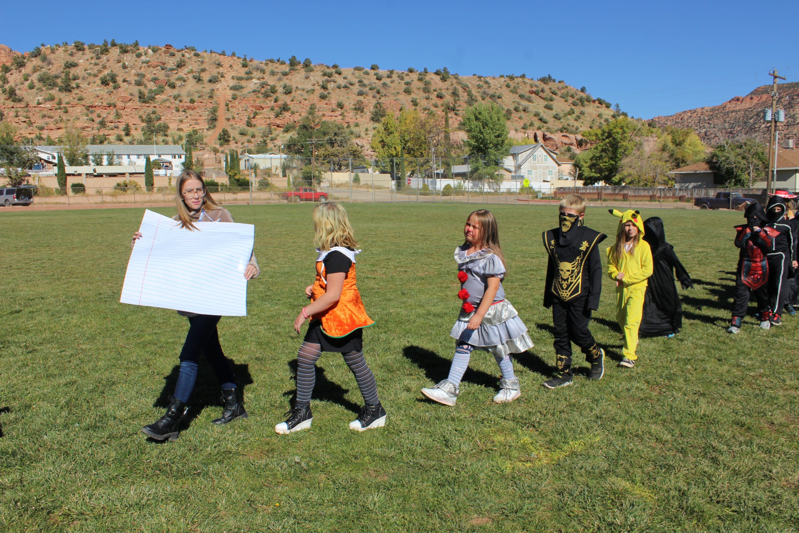 Students and a teacher in their Halloween costumes for the Halloween parade.