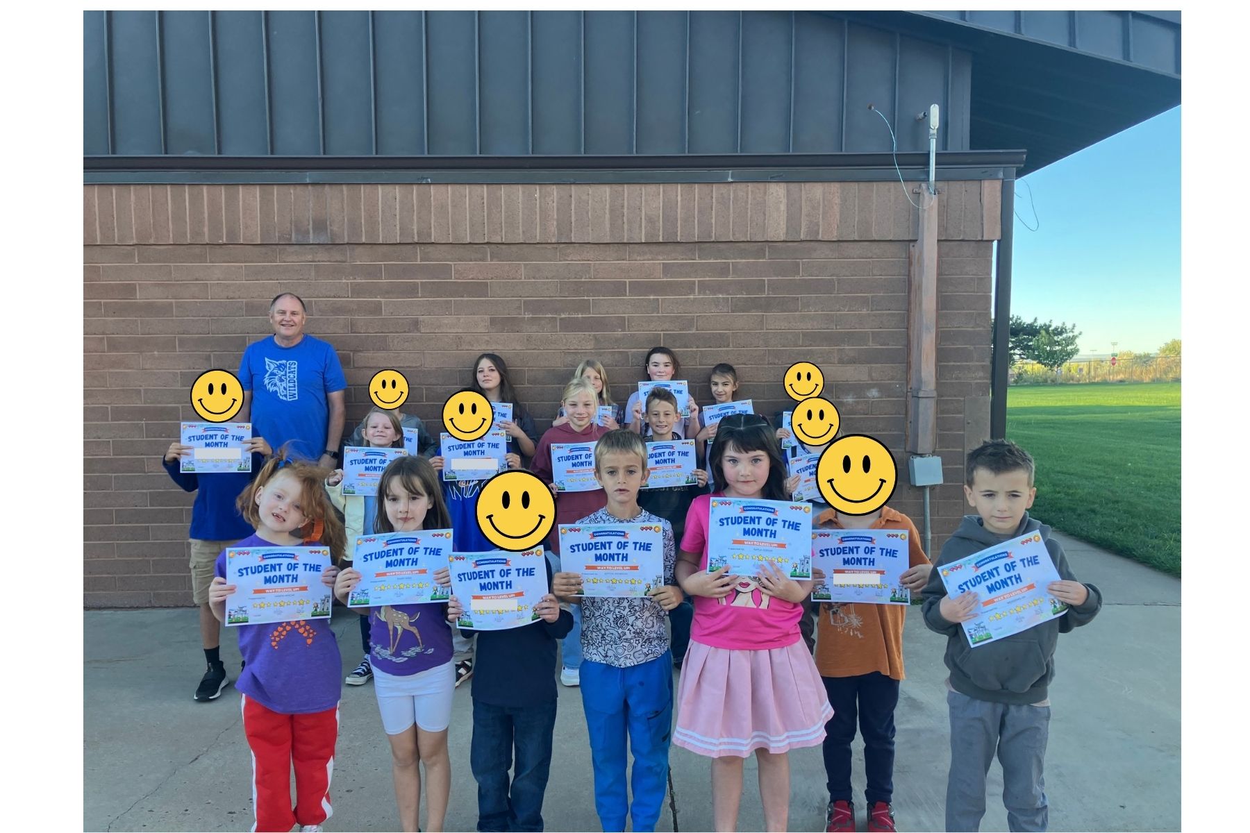 September 2026 Students of the Month and Staff Member of the Month standing outside the school